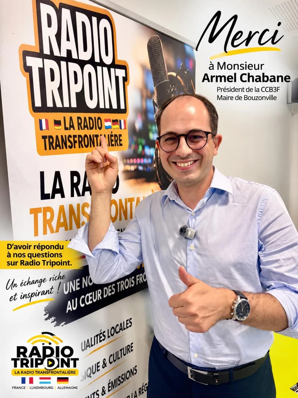 Armel Chabane lächelt mit erhobenem Daumen vor einem Radio-Tripoint-Banner, mit der Botschaft „Merci à Monsieur Armel Chabane“.